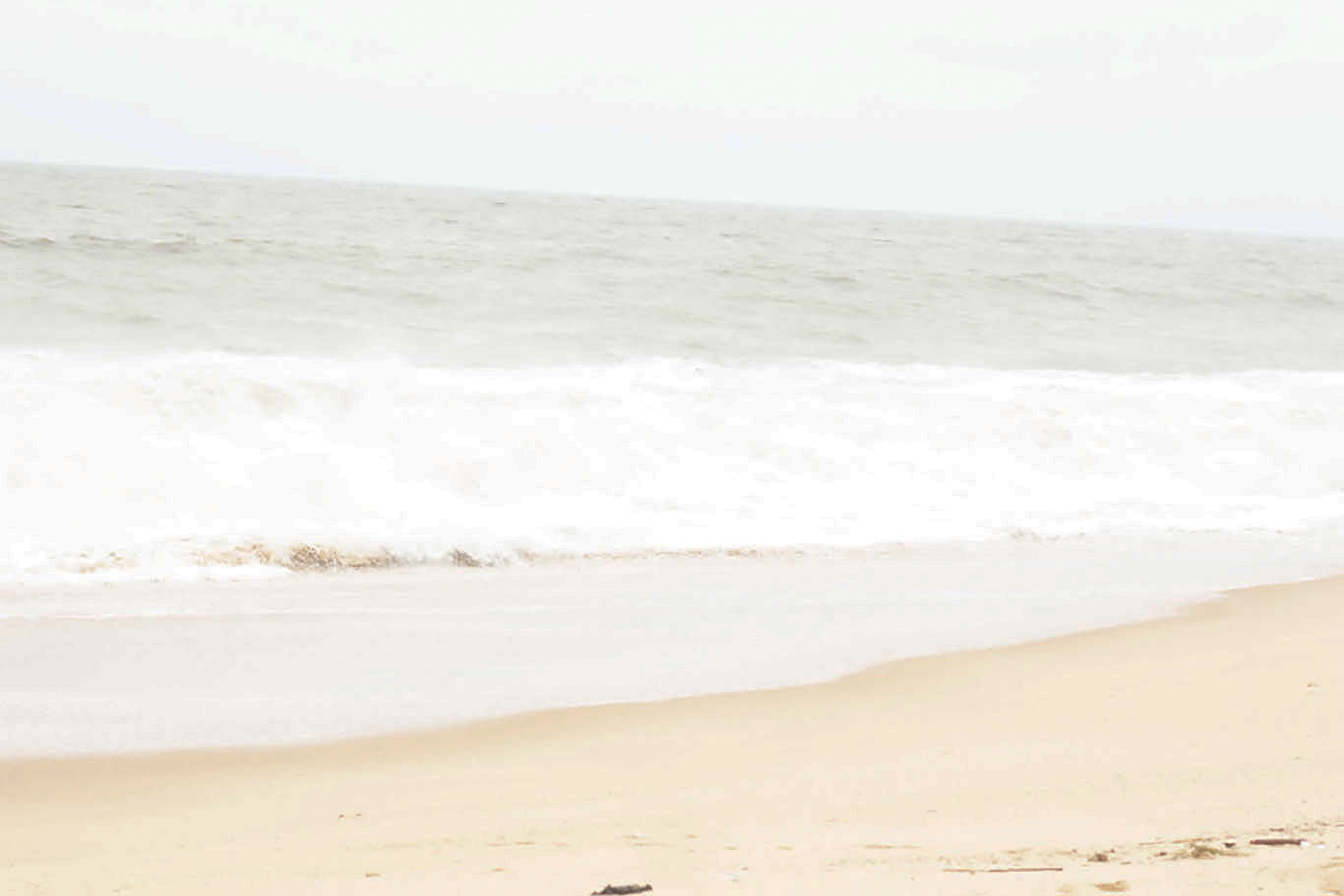 Golden sandy shore of ode omi beach with gentle Atlantic waves lapping the coastline in Ijebu,Nigeria.